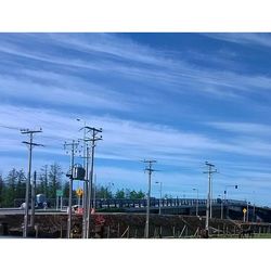 Power lines against cloudy sky