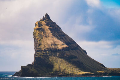 Rock formation in sea against sky