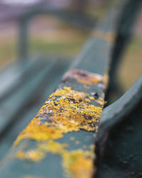 Close-up of yellow rusty metal on road