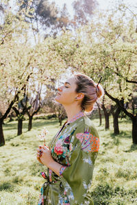 Woman standing by flower tree