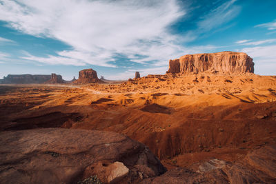 Rock formations on landscape against cloudy sky