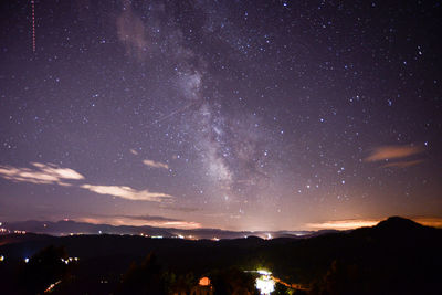 Scenic view of silhouette mountains against sky at night