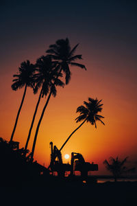 Silhouette palm trees against sky during sunset