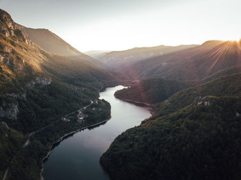 Scenic view of lake by mountains against sky