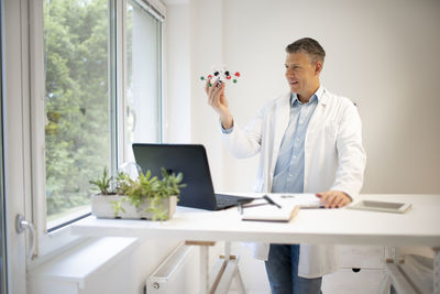 Male doctor looking at molecular structure at hospital