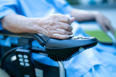 Midsection of senior woman sitting on wheelchair