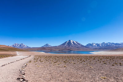 Scenic view of desert against clear blue sky