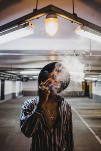 Portrait of man holding cigarette at home