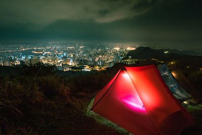 High angle view of illuminated cityscape against sky at night