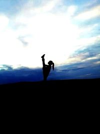 Silhouette man standing on landscape against sky