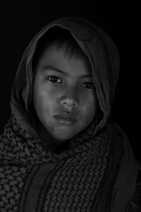 Portrait of boy against black background