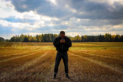 Full length of man standing on field against sky