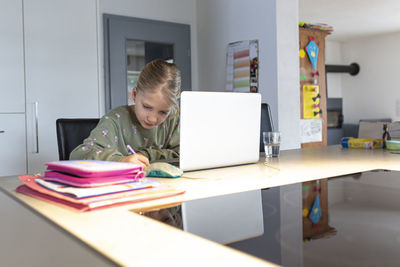 Boy sitting on table at home