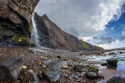Scenic view of waterfall against sky