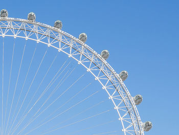 Low angle view of ferris wheel against clear blue sky