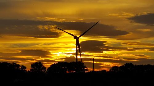 Silhouette windmill against sky during sunset