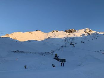 Scenic view of snowcapped mountains against clear blue sky