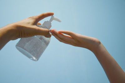 Low angle view of hands holding blue sky