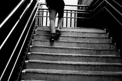 Rear view of person walking on staircase