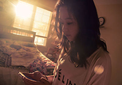 Close-up of young woman relaxing on bed at home