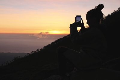 Man photographing at sunset