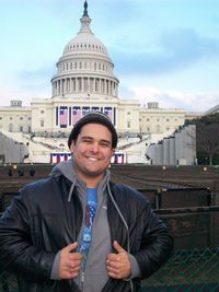 Portrait of smiling young man standing against capitol building in city