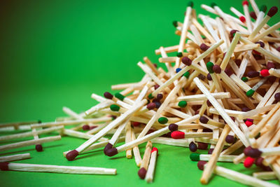 Close-up of colorful matchsticks on green background