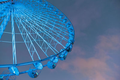 Low angle view of ferris wheel against blue sky