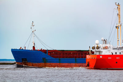 Sailboats moored on sea against clear sky