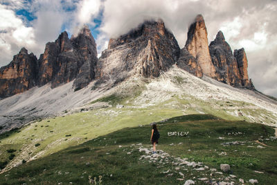 Rear view of person on rocks against sky