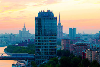 Skyscrapers in city against sky during sunset