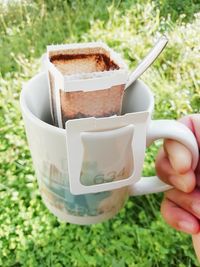 Close-up of hand holding coffee cup