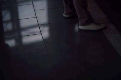 Low section of woman standing on tiled floor