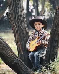 Portrait of boy on tree trunk