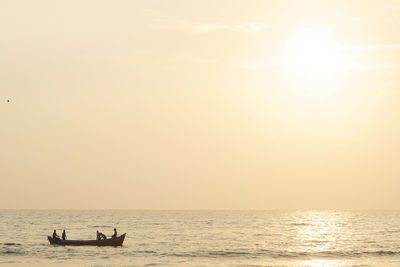 Boat in sea against clear sky during sunset