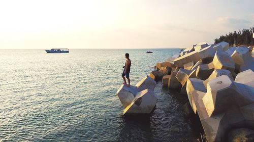 Low section of man on beach against sky