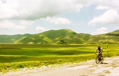 Bicycling on country road along landscape