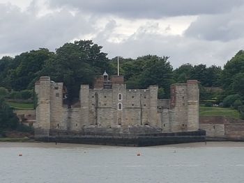 Castle by trees against sky