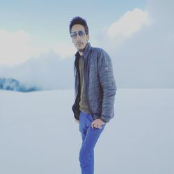 Portrait of young man standing against sky during winter