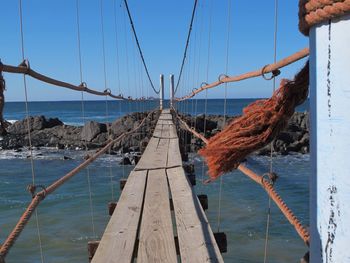 Clothes hanging on bridge over river against sky