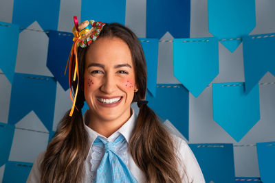 Portrait of young woman standing against wall