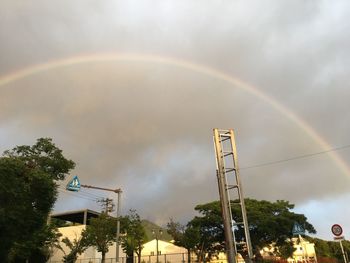 Low angle view of rainbow over city against sky