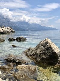 Scenic view of rocks in sea against sky