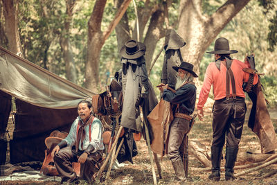 People by tent in forest