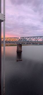 Bridge over river against cloudy sky