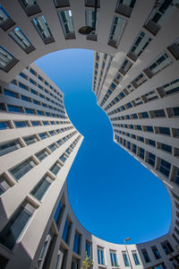 Low angle view of modern buildings against blue sky