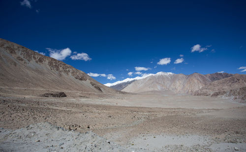 Scenic view of snowcapped mountains against blue sky