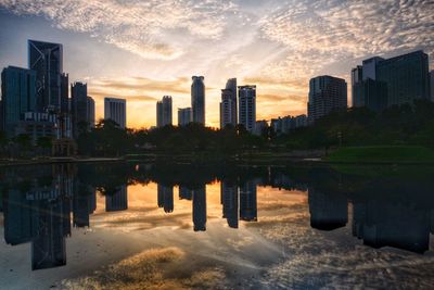 Reflection of buildings in city at sunset