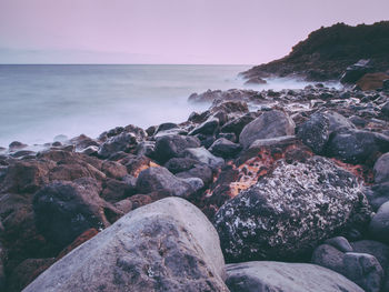 Rocks on beach against sky