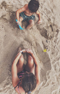 View from above of a boy and his mother playing on the beach